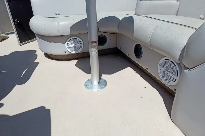 Slide: The Image of 2003 Godfrey SANPAN 2500 boat interior with cushioned seating and built-in speakers. - 16