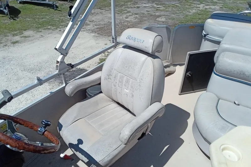 Slide: The Image of 2003 Godfrey SANPAN 2500 boat interior with white captain's chair and steering wheel. - 17