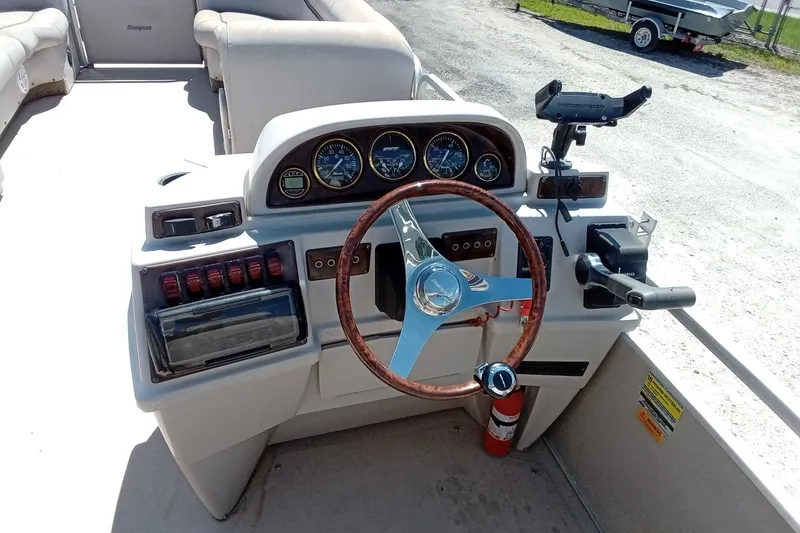 Slide: The Image of 2003 Godfrey SANPAN 2500 boat dashboard with steering wheel and control panel. - 18