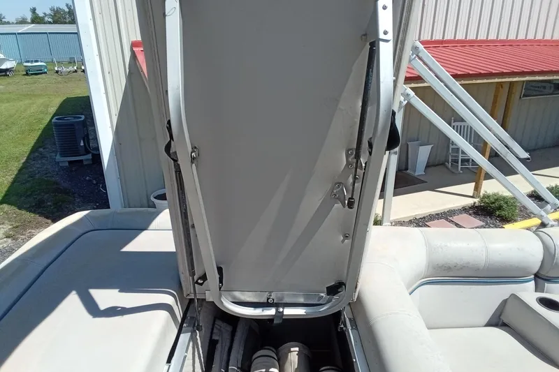 Slide: The Image of 2003 Godfrey SANPAN 2500 boat with open storage compartment, outdoor setting. - 23