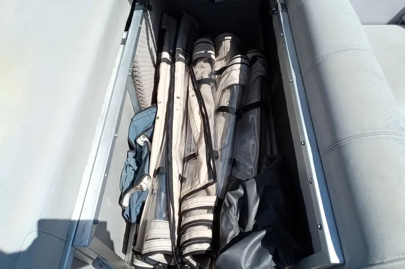 Slide: The Image of Storage compartment on a 2003 Godfrey SANPAN 2500 boat with rolled-up covers. - 24
