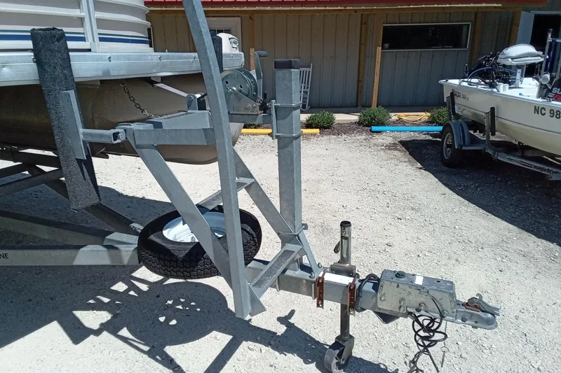 Slide: The Image of Trailer hitch of a 2003 Godfrey SANPAN 2500 pontoon boat in a gravel lot. - 4