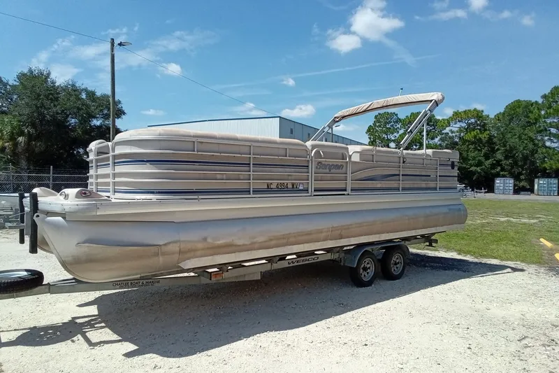 Slide: The Image of 2003 Godfrey SANPAN 2500 pontoon boat on trailer, parked outdoors under clear sky. - 7