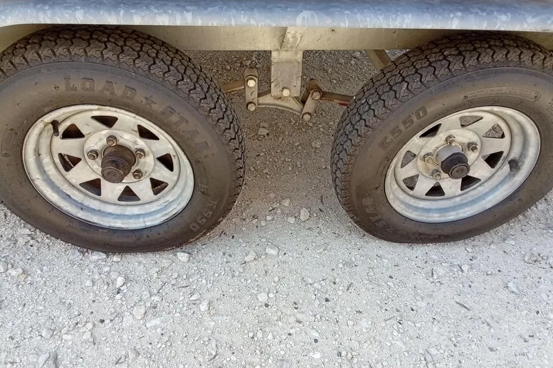 Slide: The Image of Dual wheels of a 2003 Godfrey SANPAN 2500 trailer on gravel surface. - 8