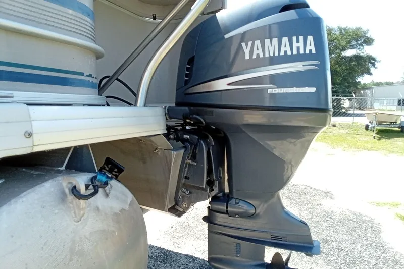 Slide: The Image of 2003 Godfrey SANPAN 2500 with Yamaha four-stroke outboard motor, docked outdoors. - 9