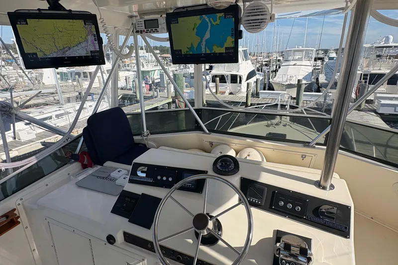 Slide: The Image of 1988 Egg Harbor 37 Convertible boat docked, featuring a spacious deck and scenic water view. - 14