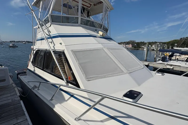 Slide: The Image of 1988 Egg Harbor 37 Convertible yacht docked in a marina under clear skies. - 2