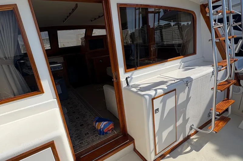 Slide: The Image of 1988 Egg Harbor 37 Convertible yacht docked, featuring sleek design and American flag. - 3