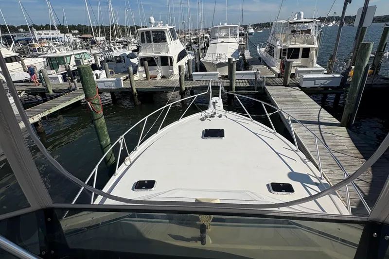 Slide: The Image of 1988 Egg Harbor 37 Convertible yacht docked at a marina under a clear blue sky. - 6