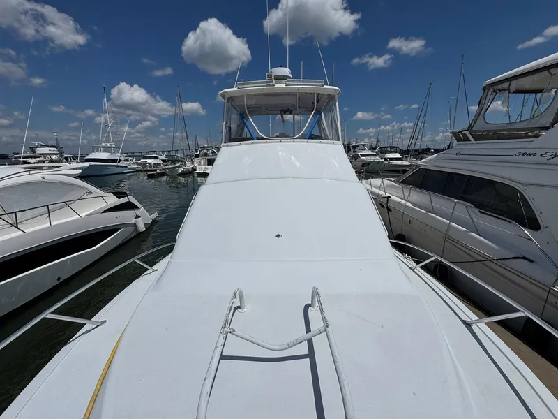 Slide: The Image of 1998 Ocean Yachts 40 Super Sport docked among other boats under a blue sky. - 11