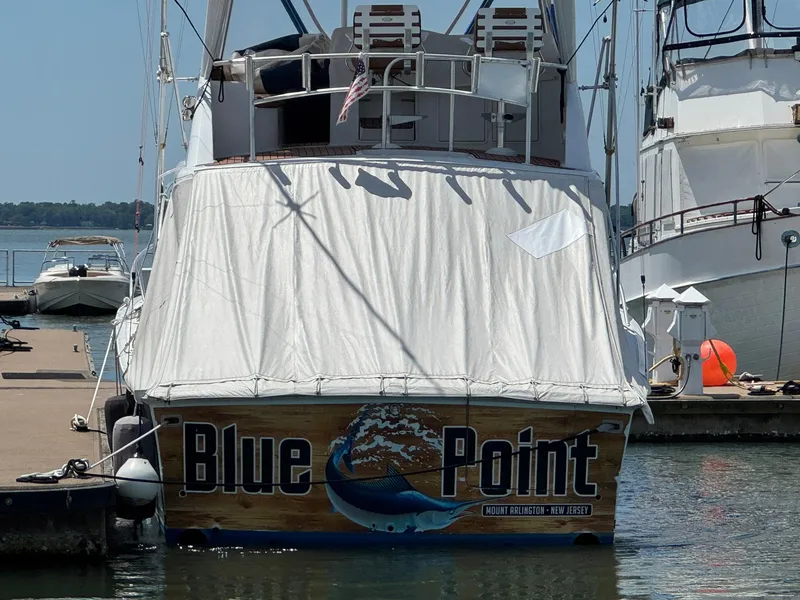 Slide: The Image of 1998 Ocean Yachts 40 Super Sport docked, covered, with "Blue Point" signage. - 2