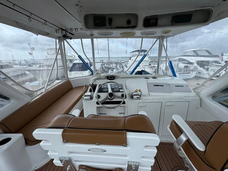 Slide: The Image of 1998 Ocean Yachts 40 Super Sport helm with brown seating and marina view. - 23