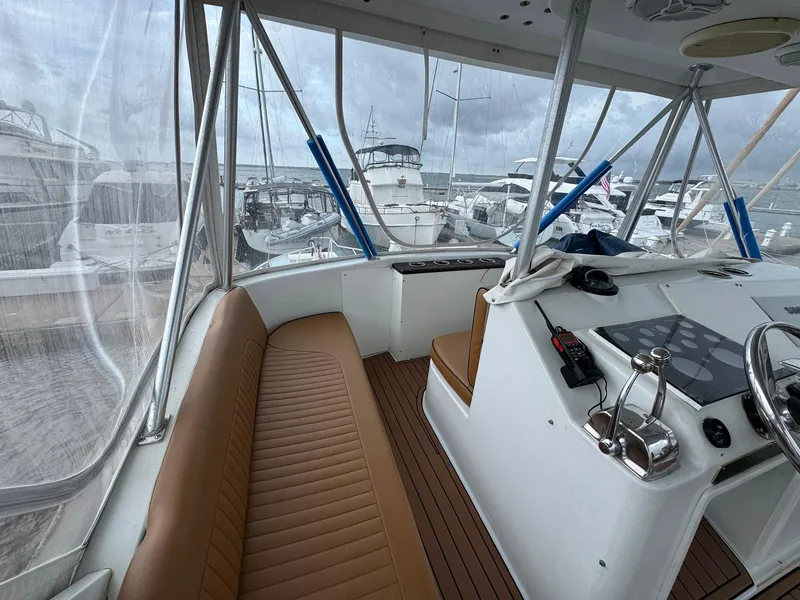 Slide: The Image of 1998 Ocean Yachts 40 Super Sport interior with helm, brown seating, and marina view. - 24