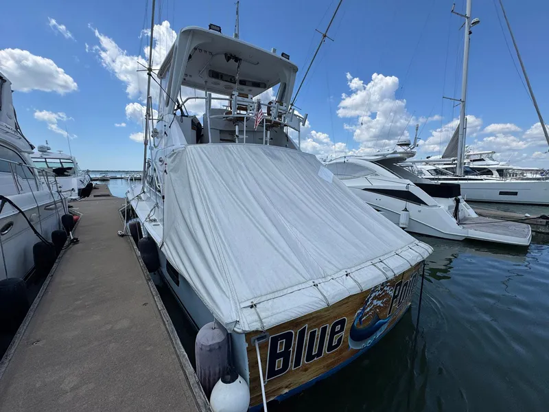 Slide: The Image of 1998 Ocean Yachts 40 Super Sport docked, covered, with clear sky and other boats nearby. - 6