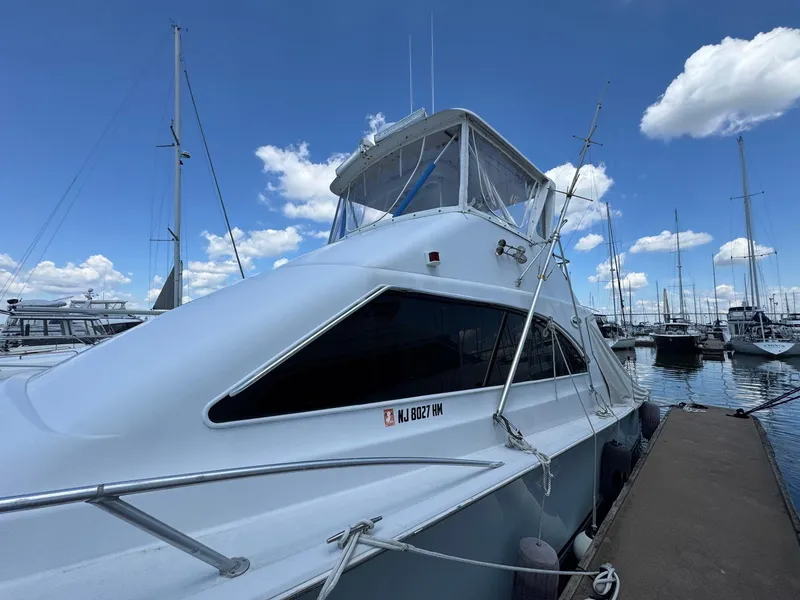Slide: The Image of 1998 Ocean Yachts 40 Super Sport docked at marina under blue sky. - 7