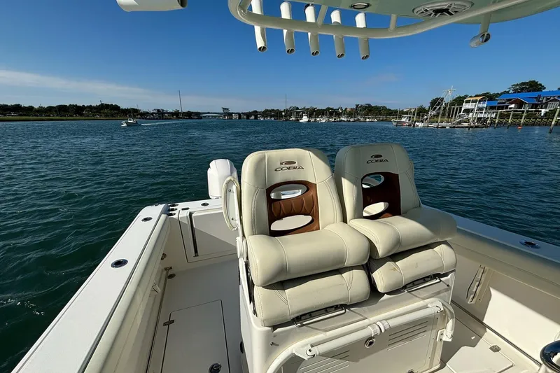 Slide: The Image of 2020 Cobia 280 Center Console boat on water, featuring comfortable seating and scenic view. - 10
