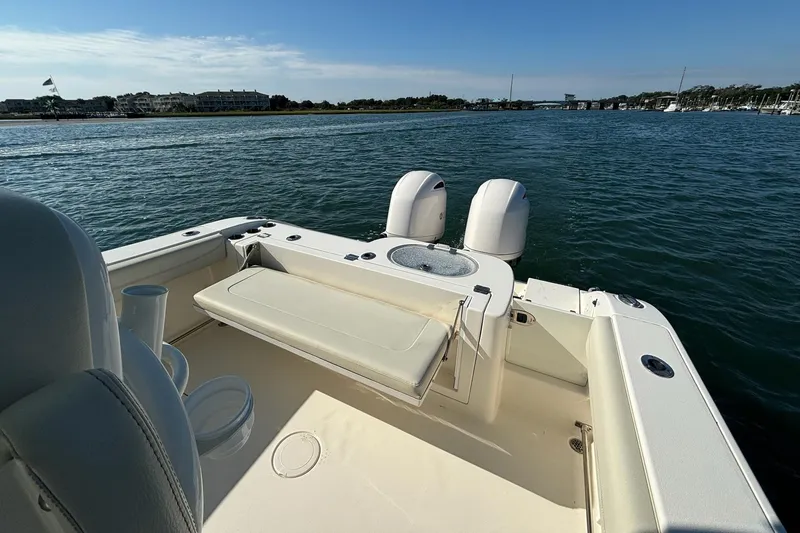 Slide: The Image of 2020 Cobia 280 Center Console boat on calm water, featuring dual engines and seating. - 11