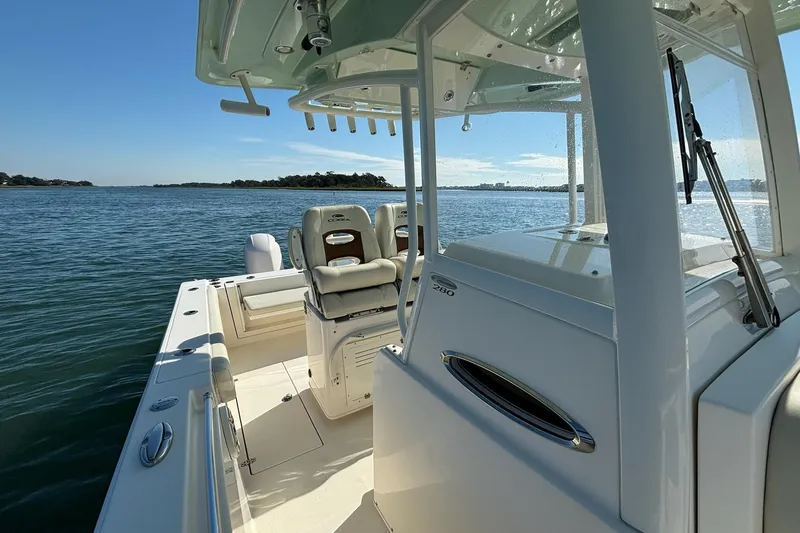 Slide: The Image of 2020 Cobia 280 Center Console boat on calm waters, showcasing sleek design and spacious deck. - 12