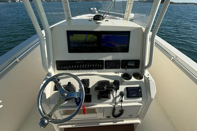 Slide: The Image of 2020 Cobia 280 Center Console boat dashboard with steering wheel and navigation screens. - 16