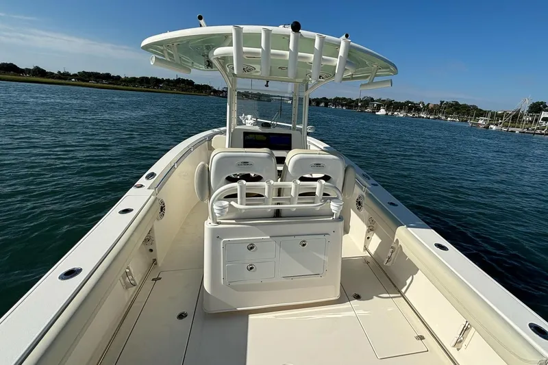 Slide: The Image of 2020 Cobia 280 Center Console boat on calm water, featuring spacious deck and seating. - 17