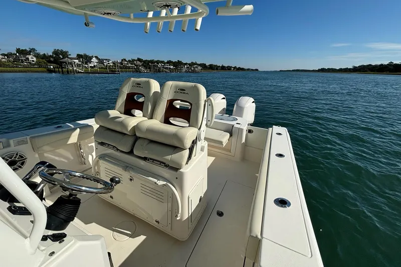 Slide: The Image of 2020 Cobia 280 Center Console boat on calm water, featuring comfortable seating and steering wheel. - 18