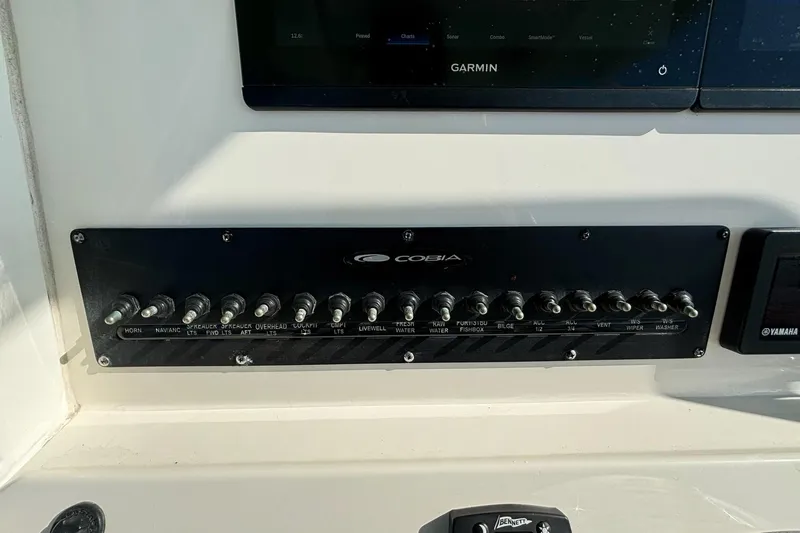Slide: The Image of Control panel of a 2020 Cobia 280 Center Console boat with labeled switches. - 21
