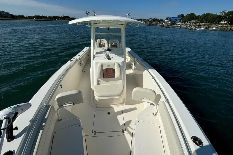 Slide: The Image of 2020 Cobia 280 Center Console boat on calm water, showcasing spacious deck and seating. - 23