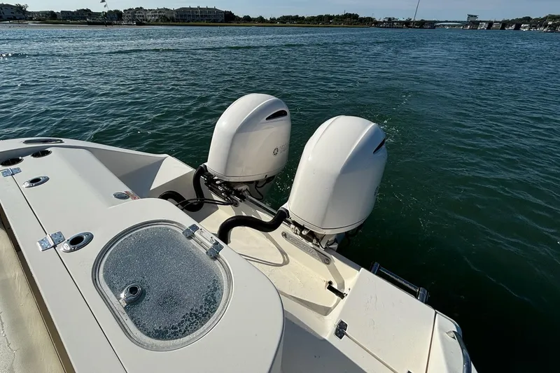 Slide: The Image of 2020 Cobia 280 Center Console boat with dual outboard motors on the water. - 24