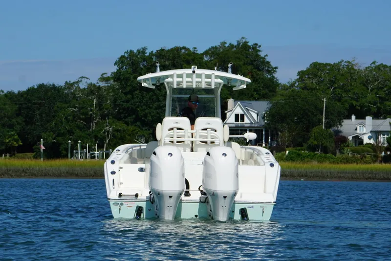 Slide: The Image of 2020 Cobia 280 Center Console boat on water, with scenic shoreline background. - 5