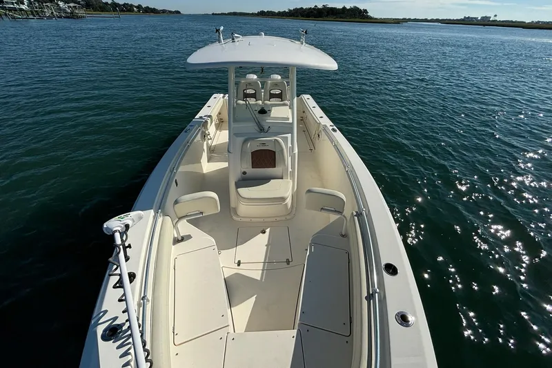Slide: The Image of 2020 Cobia 280 Center Console boat on calm water, showcasing spacious deck and seating. - 8
