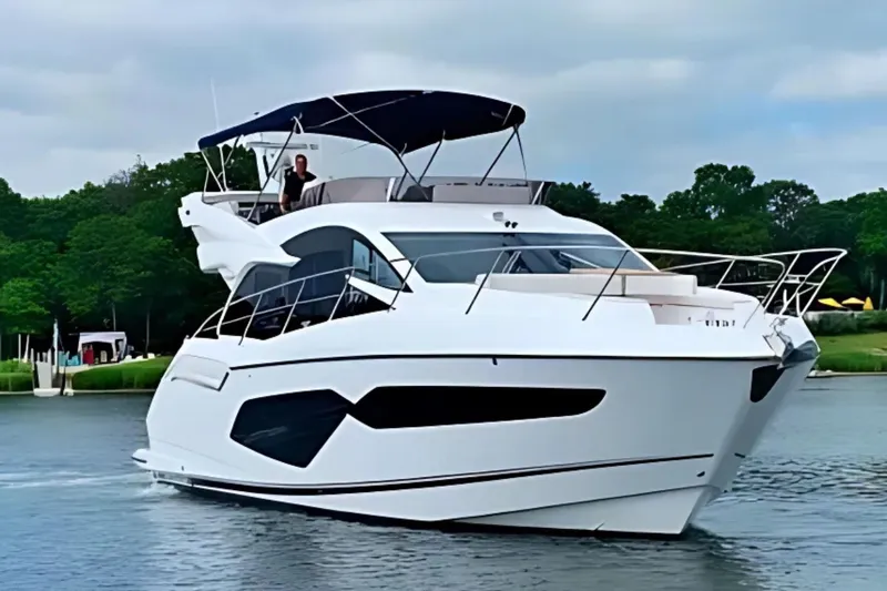 Slide: The Image of 2018 Sunseeker Manhattan 52 yacht cruising on a serene waterway. - 1