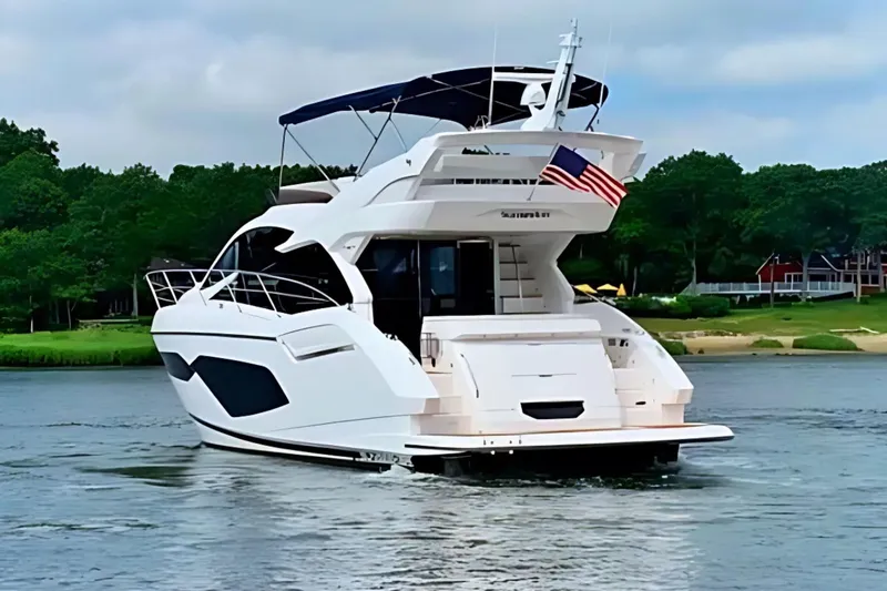 Slide: The Image of 2018 Sunseeker Manhattan 52 yacht cruising on a serene waterway. - 4