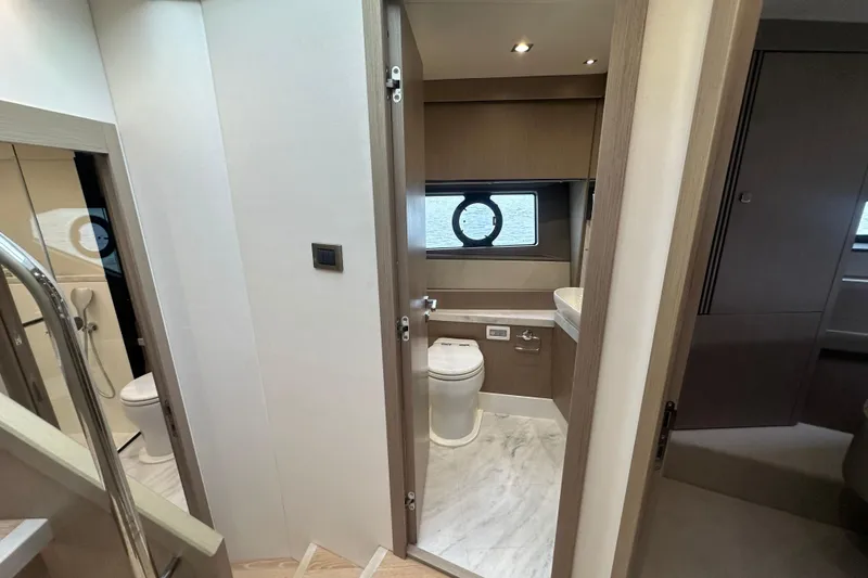 Slide: The Image of Interior of 2018 Sunseeker Manhattan 52 yacht, featuring a modern bathroom with porthole window. - 53