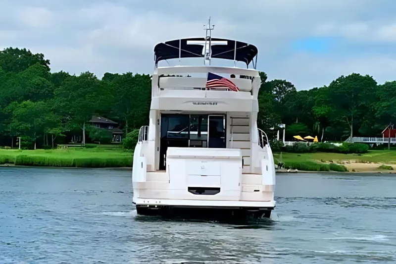 Slide: The Image of 2018 Sunseeker Manhattan 52 yacht on a serene waterway with lush greenery. - 7