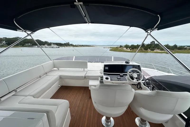 Slide: The Image of Flybridge of 2018 Sunseeker Manhattan 52 yacht with helm, seating, and scenic water view. - 75
