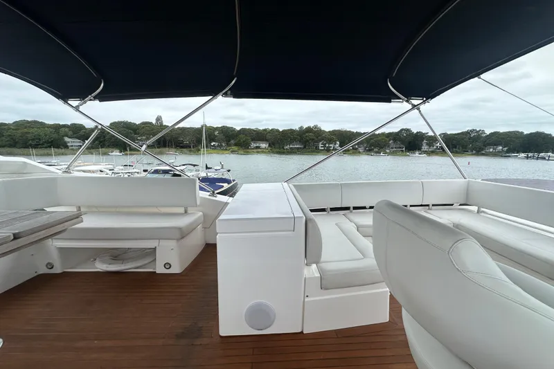 Slide: The Image of Flybridge of 2018 Sunseeker Manhattan 52 yacht with white seating and wooden deck. - 77