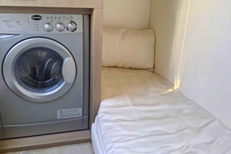 Slide: The Image of Laundry area with a washing machine and compact sleeping space on a 2018 Sunseeker Manhattan 52 yacht. - 85