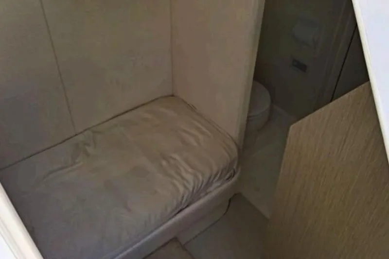 Slide: The Image of Interior cabin of 2018 Sunseeker Manhattan 52 yacht, featuring a compact bed and bathroom. - 87