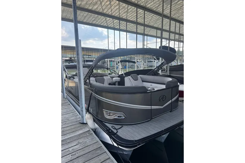 Slide: The Image of 2021 Avalon LSZ Entertainer 24' pontoon boat docked under a covered marina. - 10