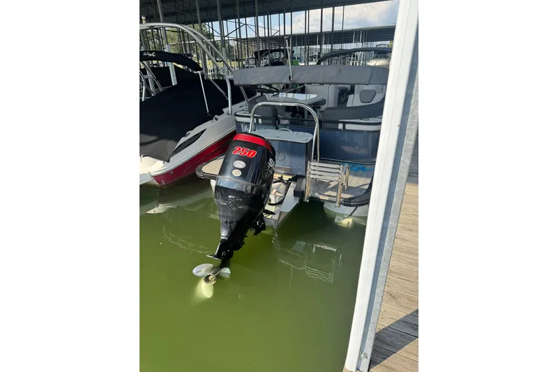 Slide: The Image of 2021 Avalon LSZ Entertainer 24' boat with 250 HP outboard motor docked in marina. - 11