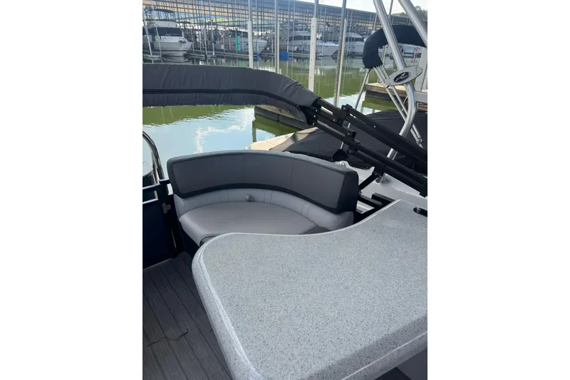 Slide: The Image of 2021 Avalon LSZ Entertainer 24' boat interior with seating and table, docked at marina. - 4