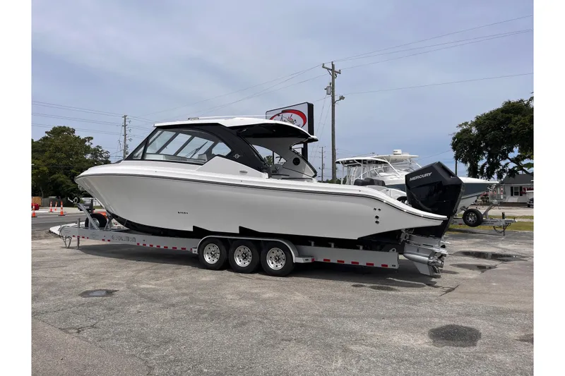 Slide: The Image of 2025 Fountain 39 DX boat on trailer, parked outdoors, side view. - 2