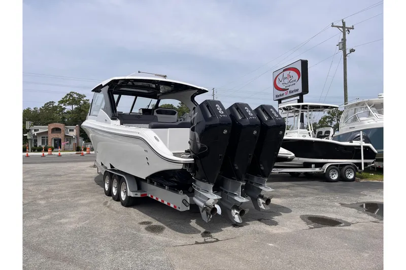 Slide: The Image of 2025 Fountain 39 DX boat with triple outboard engines on a trailer at a marina. - 3