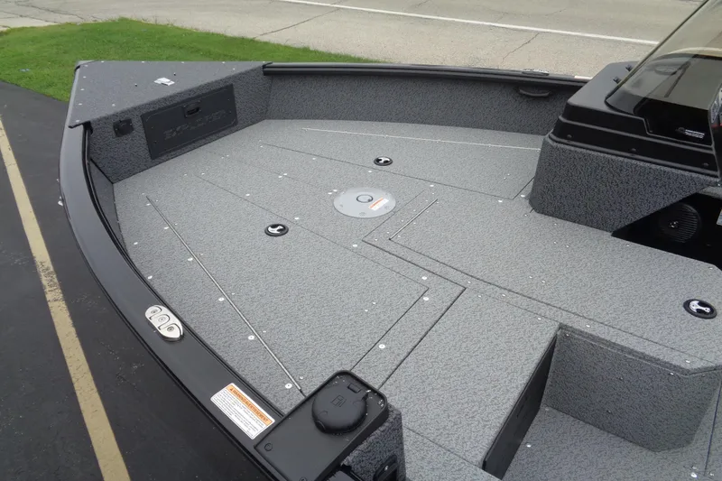 Slide: The Image of 2026 Lund 1800 Explorer SS boat deck with gray textured surface and storage compartments. - 5