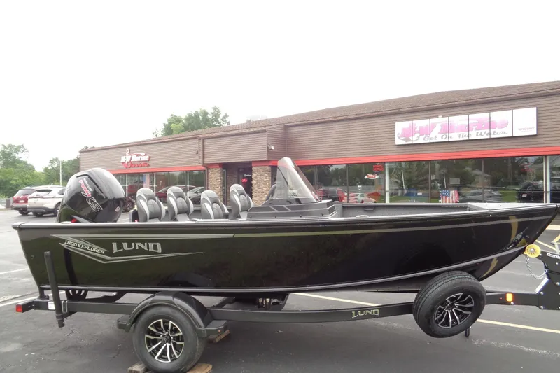Slide: The Image of 2026 Lund 1800 Explorer SS boat on trailer outside dealership. - 9