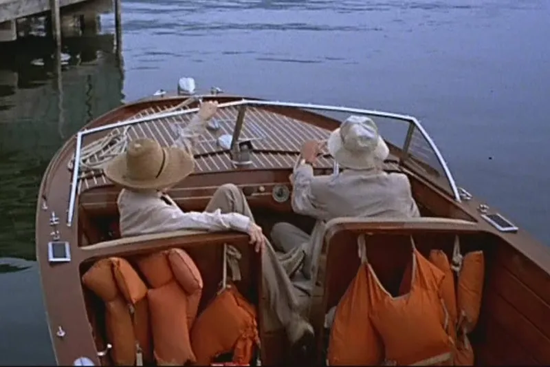 Slide: The Image of 1946 Chris-Craft U-22 Sportsman boat with two passengers on a calm lake. - 16