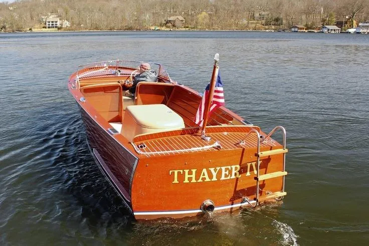 Slide: The Image of 1946 Chris-Craft U-22 Sportsman boat "Thayer IV" on a lake with American flag. - 17