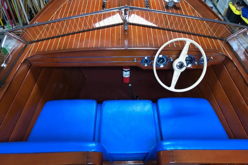 Slide: The Image of 1946 Chris-Craft U-22 Sportsman boat interior with blue seats and wooden dashboard. - 6