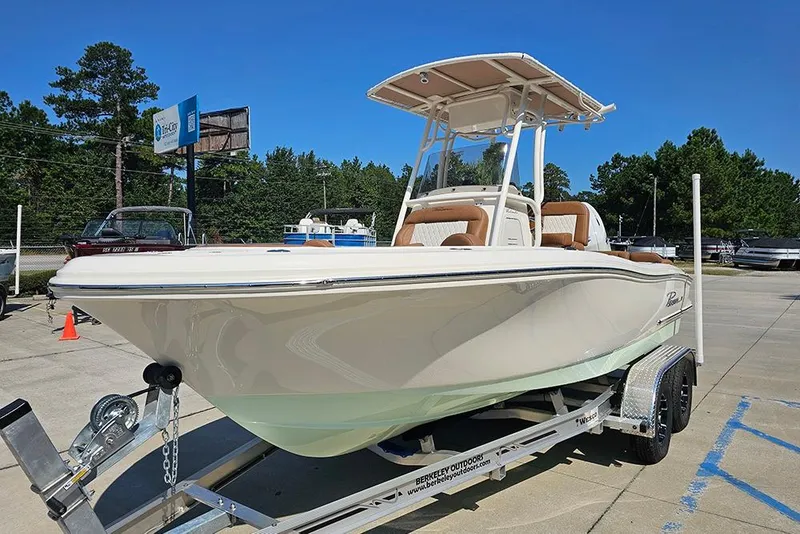 Slide: The Image of 2026 Pioneer 202 Islander boat on trailer, parked outdoors under clear blue sky. - 7