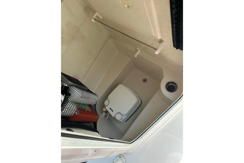 Slide: The Image of Interior storage compartment of 2022 Sailfish 220 CC boat, featuring organized space and equipment. - 18